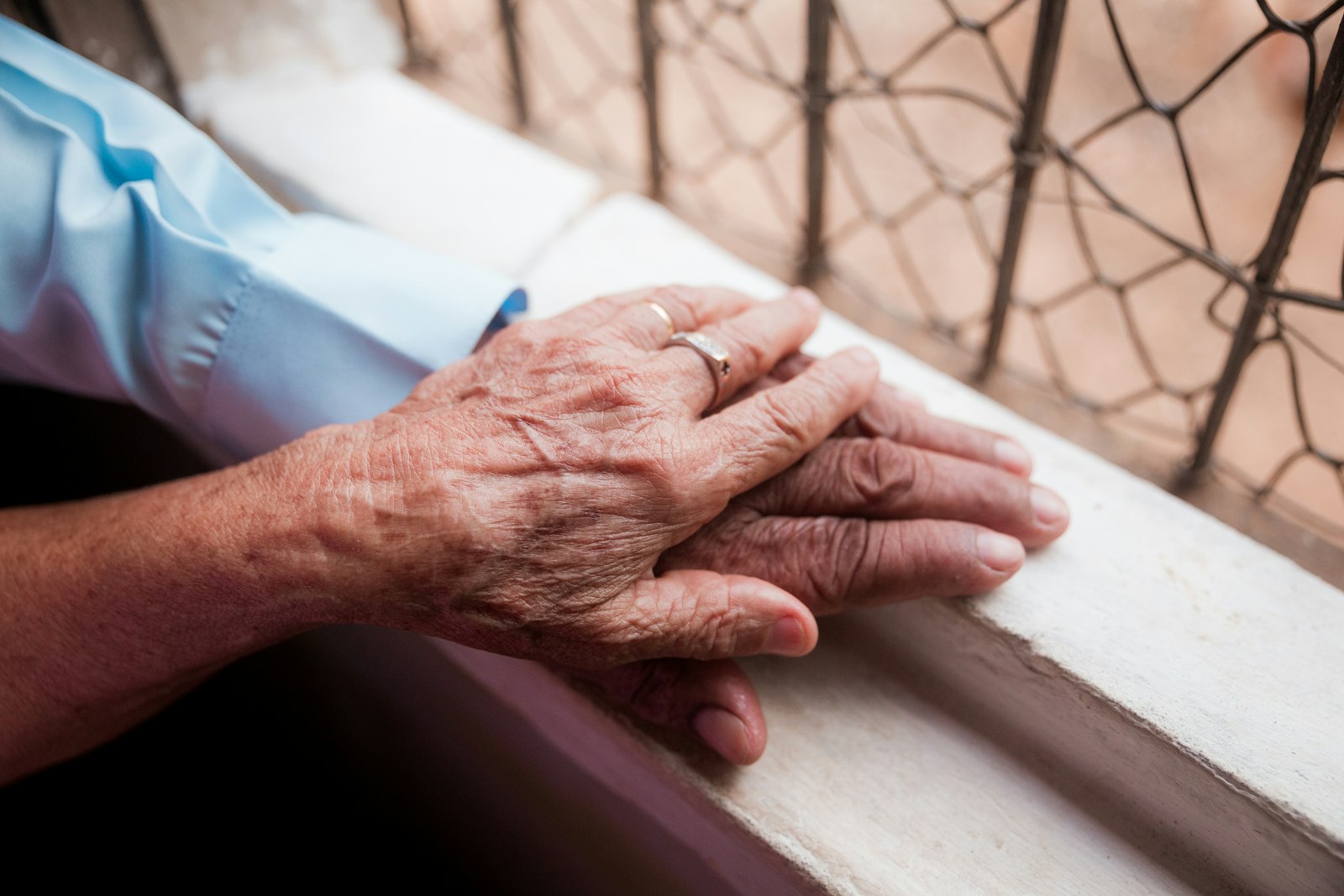 An older person's hands resting on a younger person's hand